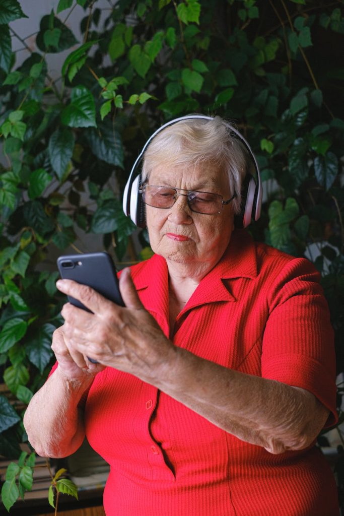 senior woman in headphones using smartphone