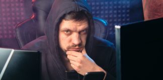 man in black hoodie holding a smartphone