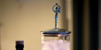 Image d'une fontaine à Absinthe, son verre et une bouteille d'absinthe de Val-de-Travers