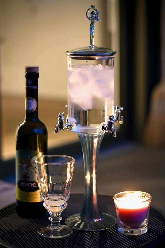Image d'une fontaine à Absinthe, son verre et une bouteille d'absinthe de Val-de-Travers